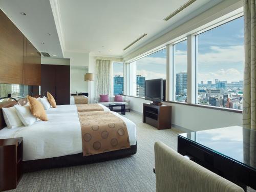 a hotel room with two beds and a tv at Hotel The Celestine Tokyo Shiba in Tokyo