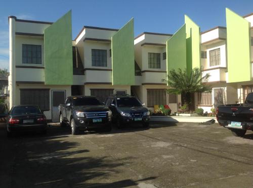 two cars parked in a parking lot in front of a building at Danel Pensionne House in Tacloban