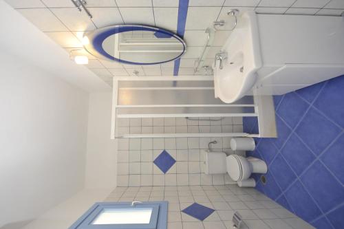 a blue and white bathroom with a toilet and a sink at Evita Apartments in Aliki