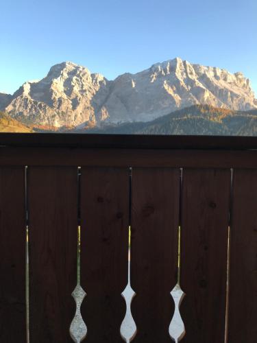 a view of snow covered mountains from a fence at Ciasa Raut in La Valle