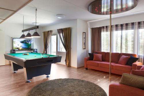 a living room with a pool table and a couch at Vuokatin Aateli Villa Keisari in Vuokatti