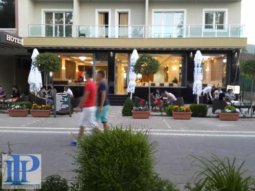 a man walking down a street next to a building at Hotel Pogradeci in Pogradec