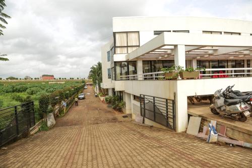 a white building with a brick walkway in front of it at Pai Resort in Belgaum