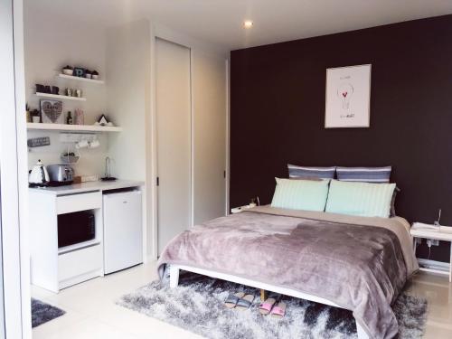 1 dormitorio con cama y pared negra en New Market Cozy Room en Auckland