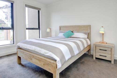 ein Schlafzimmer mit einem großen Bett und zwei Fenstern in der Unterkunft Sullivan's Retreat in Rye