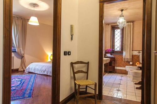 カターニアにあるCasa Dimora Vittoriaのベッドルーム1室(ベッド1台、椅子1脚、バスルーム付)