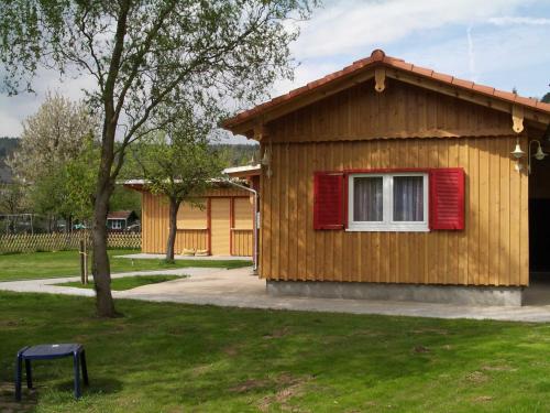 ein kleines Holzhaus mit einem roten Fenster in der Unterkunft Berliner Hütte in Neustadt