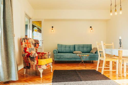 ein Wohnzimmer mit einem blauen Sofa und einem Tisch in der Unterkunft Artsy Old Town Apartment in Bukarest