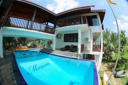 a villa with a swimming pool and a house at Marina Bentota in Bentota