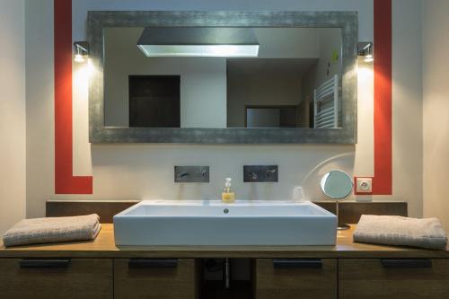 une salle de bain avec un grand lavabo et un miroir dans l'établissement L'Imprimerie, à Lyon