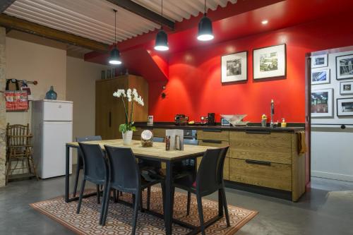 une cuisine avec une table en bois et un mur rouge dans l'établissement L'Imprimerie, à Lyon