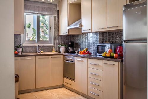a kitchen with white cabinets and stainless steel appliances at Villa Nora in Protaras