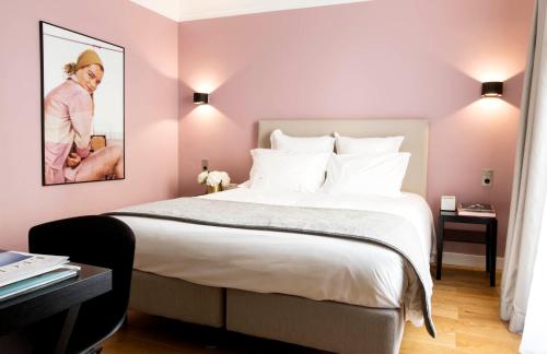 a bedroom with a large bed with pink walls at Hôtel Mathis Elysées in Paris