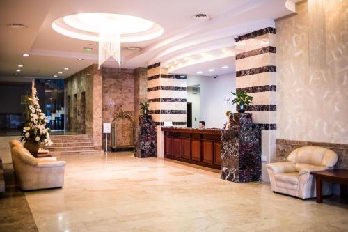 a lobby with two chairs and a reception desk at Grand Hotel in Târgu-Mureş