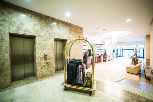 a hotel lobby with a luggage cart in the middle at Grand Hotel in Târgu-Mureş