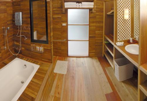 un baño con bañera y lavabo en Boutique Raft Resort, River Kwai, en Sai Yok