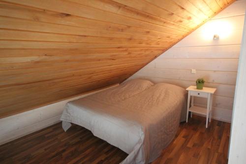 a bed in a room with a wooden ceiling at Villa Alex in Virttaa