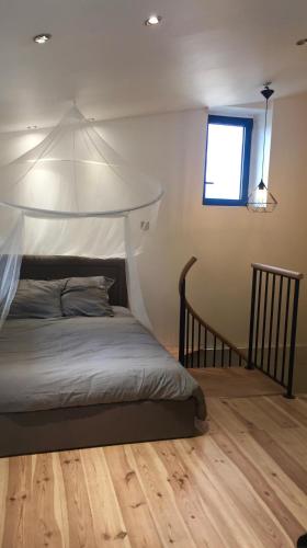 une chambre avec un lit à baldaquin dans l'établissement Au marche des Capucins by Cocoonr, à Bordeaux