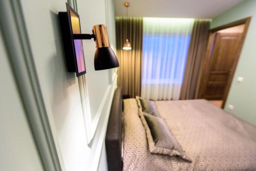 a small bedroom with a bed and a lamp at Villa Orchidea in Šakiai