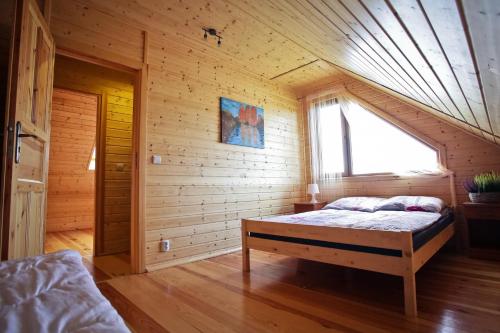 sypialnia z łóżkiem w drewnianym domku w obiekcie Zlote Domki we Władysławowie