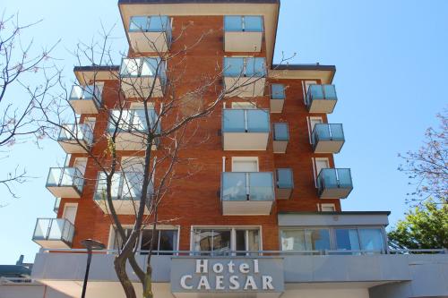 un edificio alto con balcones y un casino de hotel en Hotel Caesar en Pesaro