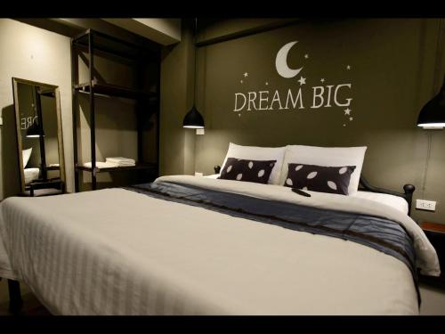 a bedroom with a bed with a dream big sign on the wall at Duangdren Place in Chiang Mai