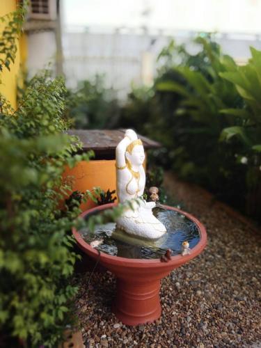 a small bird bath with two statues on it at Duangdren Place in Chiang Mai