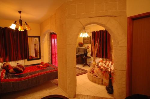 una sala de estar con un arco en una habitación con 1 dormitorio en Michal's Suites, en Sha'al