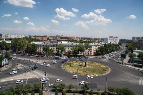 eine Stadtstraße mit Autos auf einem Parkplatz in der Unterkunft Art Studio in Taschkent