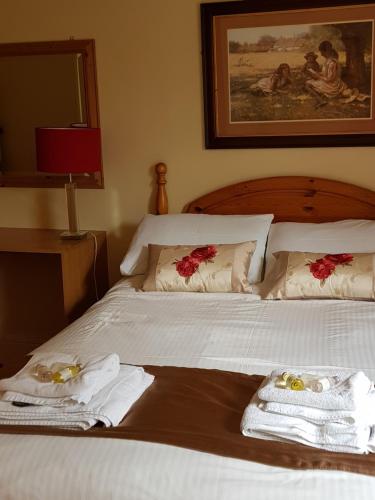 a bedroom with a bed with towels on it at The Inn On The Green in Ockley