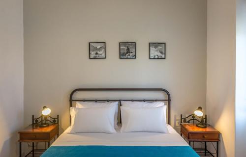 a bedroom with a bed with three pictures on the wall at Hotel Delfini in Adamantas