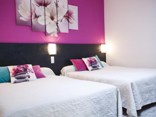 two beds in a room with purple walls at Aux Lys d'Or in Réalville