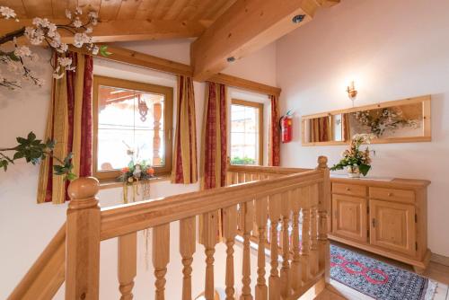 a staircase in a home with wooden railing and windows at Appartement Alpina in Alpbach