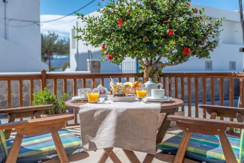 a table with food and a tree on a deck at Hotel Delfini in Adamas