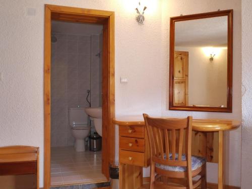 a bathroom with a table and a mirror and a toilet at Family Hotel Silver in Smolyan
