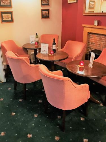 a room with tables and chairs and a fireplace at Yarn Market Hotel in Dunster