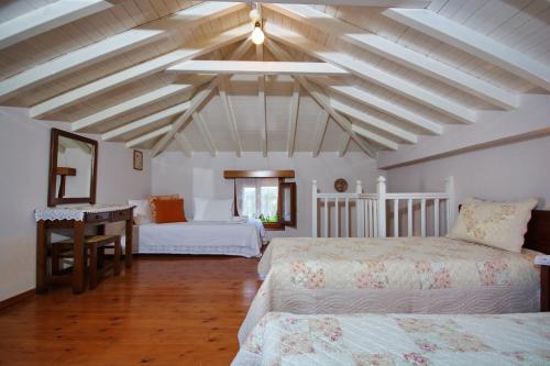 a room with two beds and a table in it at Kamelia Villas in Votsi