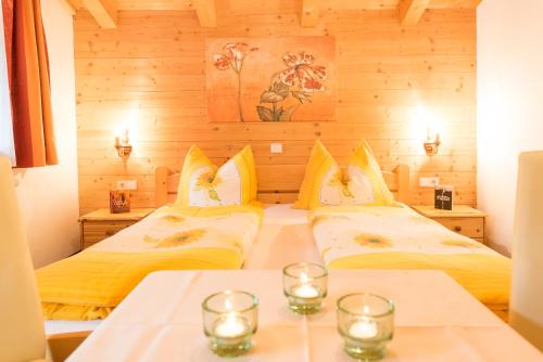 dwa łóżka w pokoju z dwoma stołami i świecami w obiekcie Appartement Alpina w Alpbach