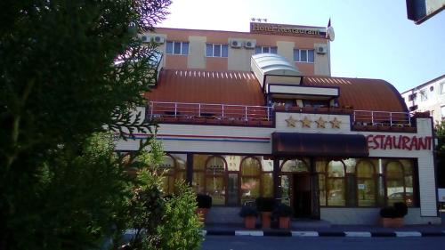 un edificio con techo rojo y un centro comercial en Hotel Sud, en Giurgiu