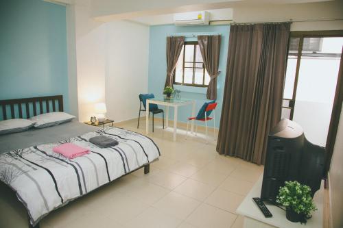 1 dormitorio con 1 cama, mesa y sillas en Baan Romdee, en Nonthaburi