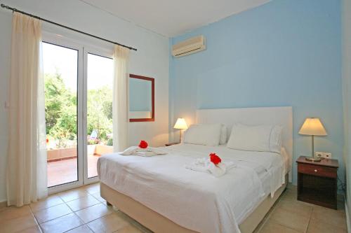 カラマキにあるVilla Armonia two bedroom aptのベッドルーム1室(赤いバラの大きな白いベッド1台付)