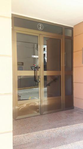 einen Eingang zu einem Gebäude mit einer Glastür in der Unterkunft Pensión Avenida in Tavernes de la Valldigna