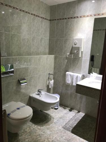 y baño con aseo y lavamanos. en Hotel Magallón, en Caspe