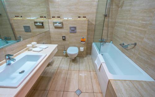 a bathroom with a tub and a toilet and a sink at Hotel Lomsia in Akhaltsikhe