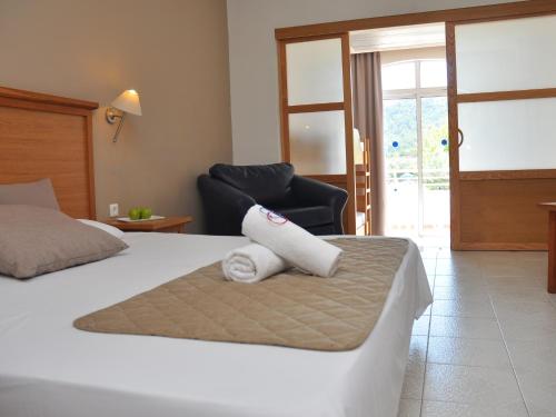 a hotel room with a bed with a towel on it at Cyprotel Faliraki in Faliraki