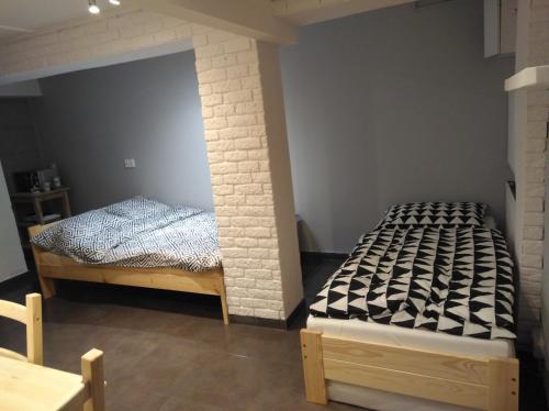 um quarto com 2 camas e uma parede de tijolos em Apartament Kniaziewicza em Breslávia
