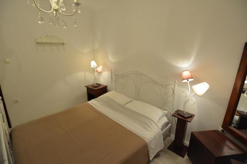 a bedroom with a bed and two lamps and a mirror at Apartment Renata in Veli Lošinj