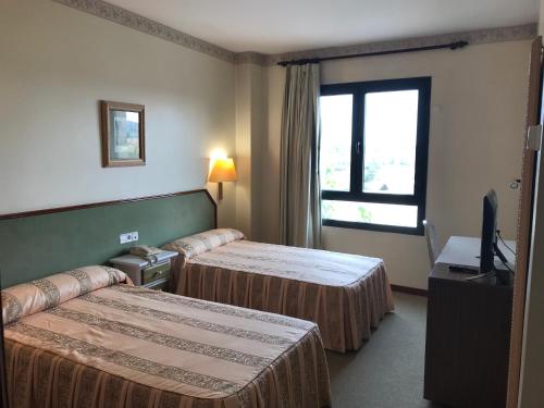 Un pat sau paturi într-o cameră la Hotel Magallón
