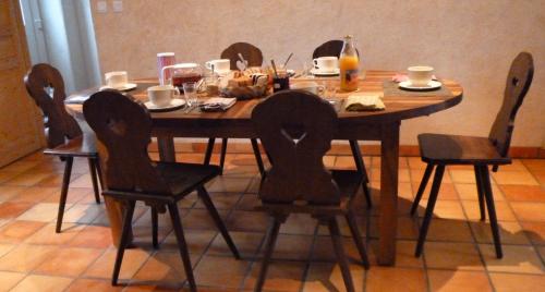 a wooden table with four chairs around it at Chambres d'Hôtes Le Bourdieu in Soulignac