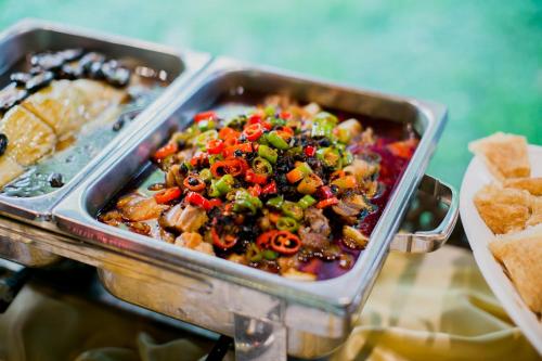 een metalen bak met voedsel, zoals groenten en brood bij E-Outfitting Doikham Resort in Chiang Mai